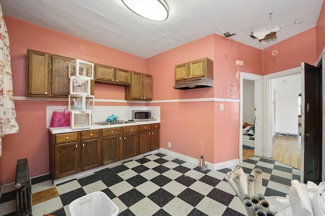 6116 S Marshfield Ave, Chicago, IL 60636 - kitchen with stainless steel microwave, under cabinet range hood, tile patterned floors, light countertops, and electric cooktop
