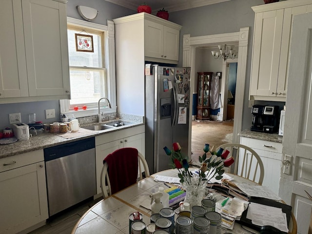 2326 Walnut St, Blue Island, IL 60406 - kitchen with appliances with stainless steel finishes, a sink, a chandelier, wood finished floors, and white cabinetry