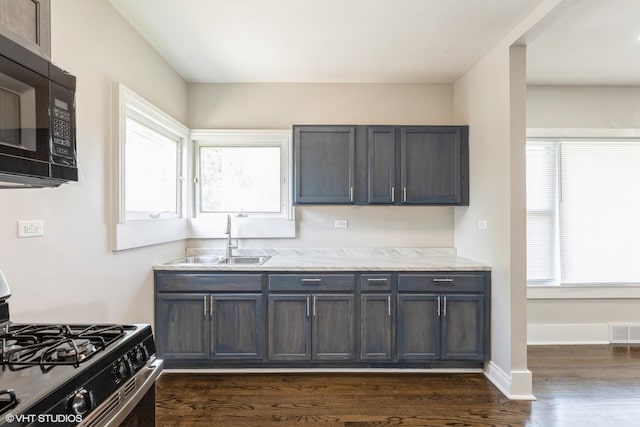3000 Chicago Rd, South Chicago Heights, IL 60411 - kitchen featuring black microwave, a sink, gas range, dark wood-type flooring, and baseboards