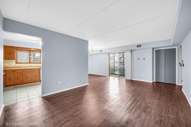 8124 168th Pl Unit 1E, Tinley Park, IL 60477 - unfurnished living room with wood finished floors, baseboards, and a sink