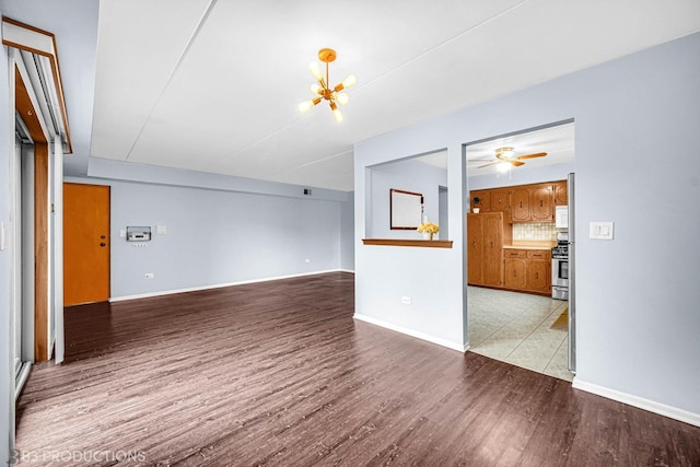 8124 168th Pl Unit 1E, Tinley Park, IL 60477 - unfurnished living room featuring light wood-style floors, baseboards, a ceiling fan, and a chandelier