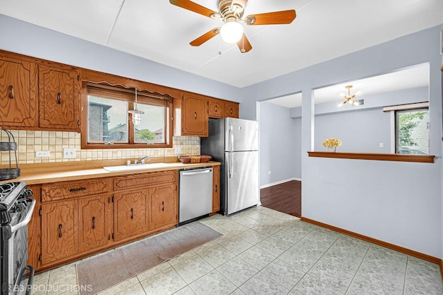 8124 168th Pl Unit 1E, Tinley Park, IL 60477 - kitchen with appliances with stainless steel finishes, a sink, tasteful backsplash, brown cabinets, and light countertops