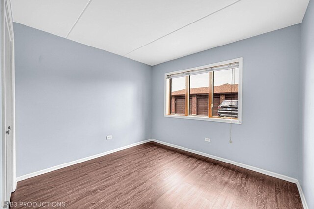 8124 168th Pl Unit 1E, Tinley Park, IL 60477 - spare room featuring baseboards and wood finished floors