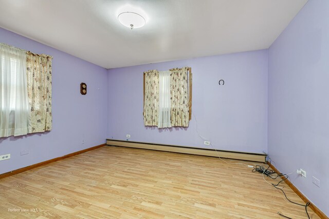 1903 Marshall Pkwy, Waukegan, IL 60085 - empty room featuring wood finished floors, healthy amount of natural light, a baseboard radiator, and baseboards