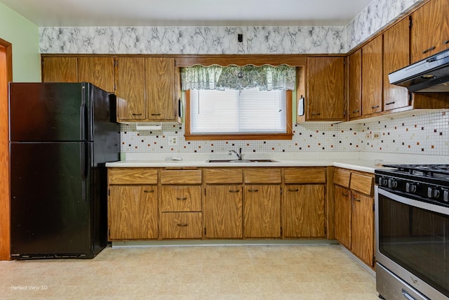 1903 Marshall Pkwy, Waukegan, IL 60085 - kitchen with freestanding refrigerator, a sink, gas stove, light countertops, and brown cabinets