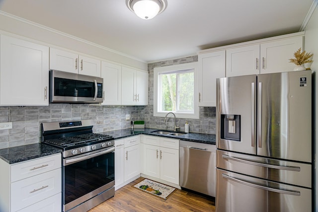 336 Manitowac St, Park Forest, IL 60466 - kitchen with appliances with stainless steel finishes, ornamental molding, white cabinetry, light wood finished floors, and dark stone counters