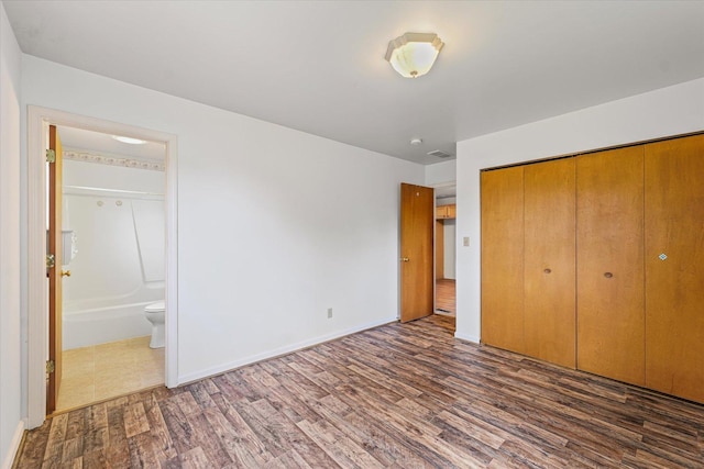 1305 W Beardsley Ave, Urbana, IL 61801 - unfurnished bedroom featuring wood finished floors, a closet, and ensuite bath