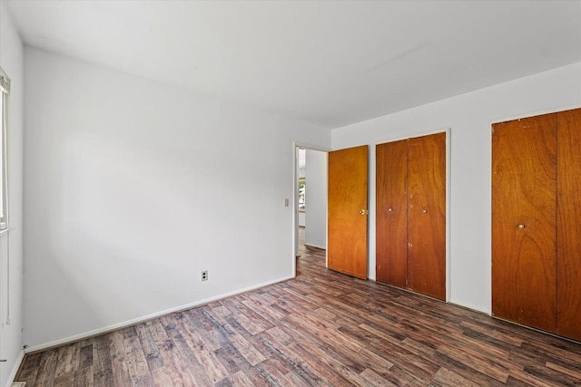 1305 W Beardsley Ave, Urbana, IL 61801 - unfurnished bedroom featuring wood finished floors and two closets
