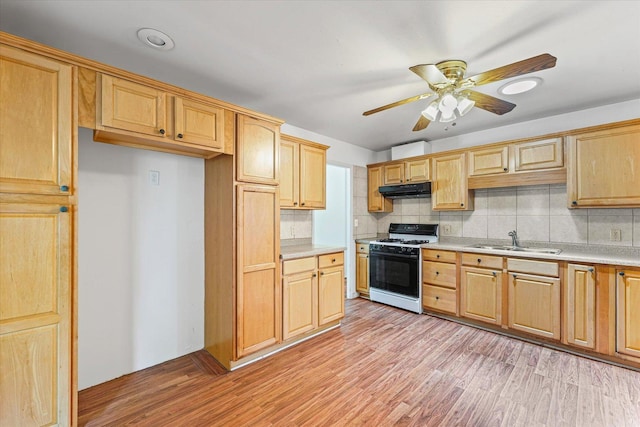 1305 W Beardsley Ave, Urbana, IL 61801 - kitchen with white gas stove, light countertops, decorative backsplash, and under cabinet range hood
