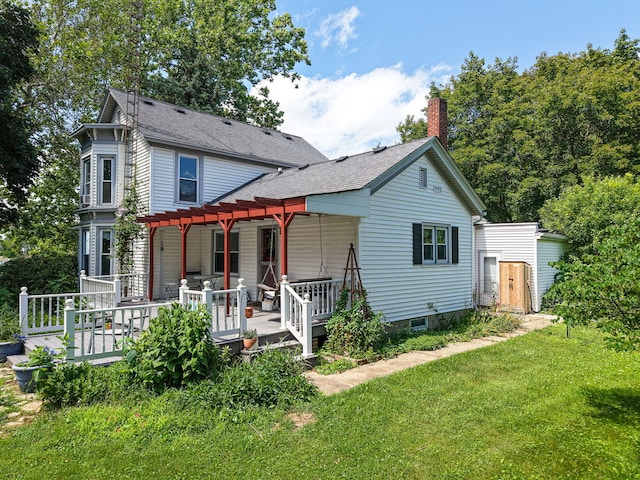 2310 N 1st St, Dekalb, IL 60115 - view of front facade with a pergola, a front yard, a shingled roof, and a chimney