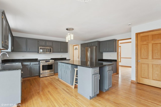 13714 S Janas Pkwy, Homer Glen, IL 60491 - kitchen with stainless steel appliances, a sink, light wood-style flooring, a kitchen island, and a kitchen bar