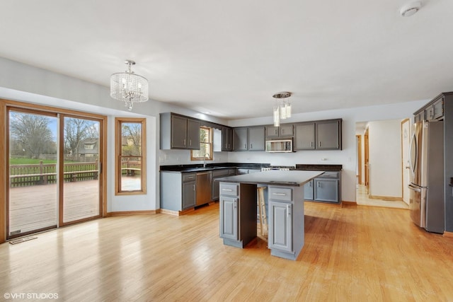 13714 S Janas Pkwy, Homer Glen, IL 60491 - kitchen featuring stainless steel appliances, dark countertops, a sink, a chandelier, and a kitchen island