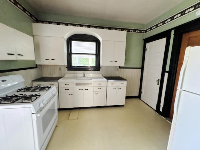 1306 E 4th St, Sterling, IL 61081 - kitchen with white appliances, white cabinets, and a sink