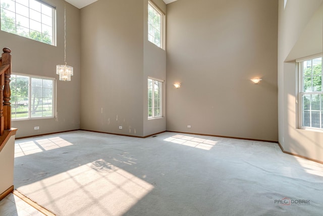 1927 Oaktree Trl, Lake Villa, IL 60046 - carpeted spare room featuring a towering ceiling, a chandelier, and baseboards