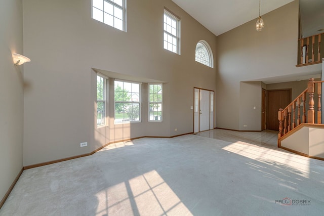 1927 Oaktree Trl, Lake Villa, IL 60046 - unfurnished living room featuring a high ceiling, healthy amount of natural light, carpet, stairs, and baseboards