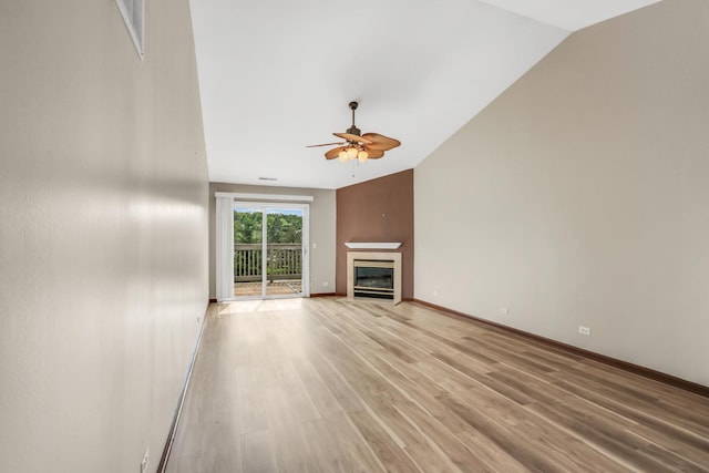 743 Sycamore Ct, Lindenhurst, IL 60046 - unfurnished living room with ceiling fan, vaulted ceiling, light wood-type flooring, and a glass covered fireplace