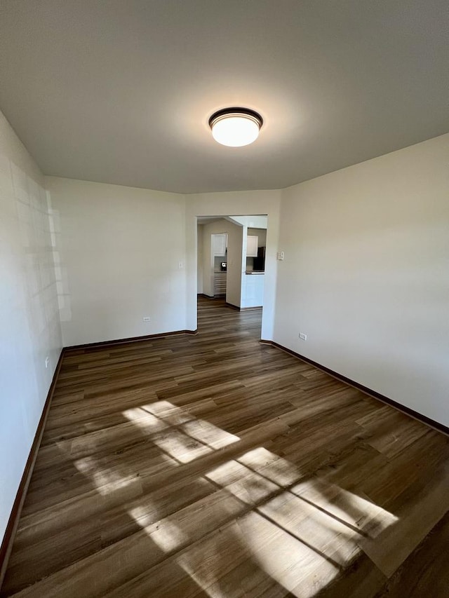 4400 W Shamrock Ln Unit 1B, Mchenry, IL 60050 - empty room with dark wood finished floors and baseboards