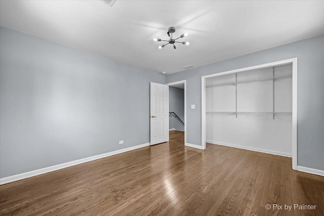 14028 S Wayman Ln, Robbins, IL 60472 - unfurnished bedroom with a closet, wood finished floors, and a chandelier
