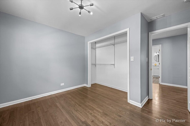 14028 S Wayman Ln, Robbins, IL 60472 - unfurnished bedroom with dark wood-type flooring, a closet, and a chandelier