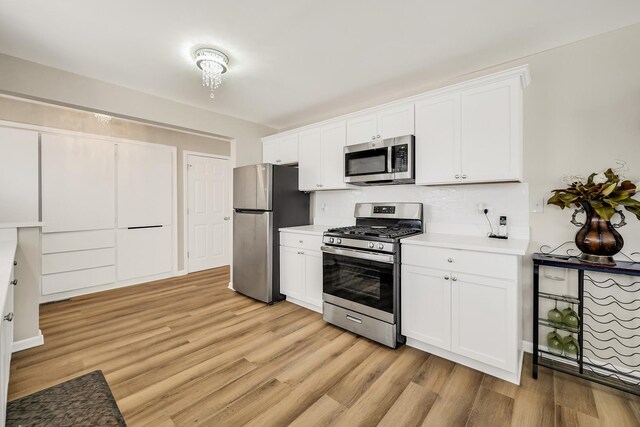 751 E 164th Pl, South Holland, IL 60473 - kitchen with appliances with stainless steel finishes, light wood finished floors, tasteful backsplash, and white cabinets