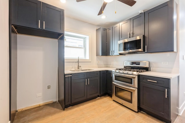 223 W 118th St, Chicago, IL 60628 - kitchen with stainless steel appliances, a sink, light wood-style floors, ceiling fan, and light countertops
