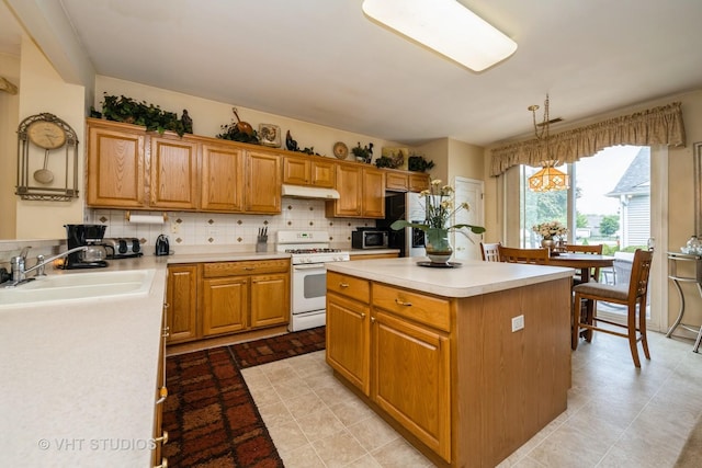 12140 Hideaway Dr, Huntley, IL 60142 - kitchen featuring white gas stove, under cabinet range hood, a center island, light countertops, and tasteful backsplash