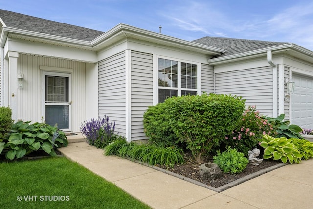 12140 Hideaway Dr, Huntley, IL 60142 - view of exterior entry featuring a garage and roof with shingles