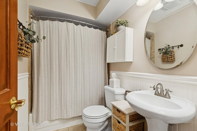 207 S Van Buren St, East Dundee, IL 60118 - full bath featuring a wainscoted wall, shower / bath combination with curtain, and tile patterned floors