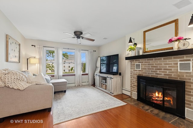 207 S Van Buren St, East Dundee, IL 60118 - living room featuring wood finished floors, a fireplace, ceiling fan, and a baseboard heating unit