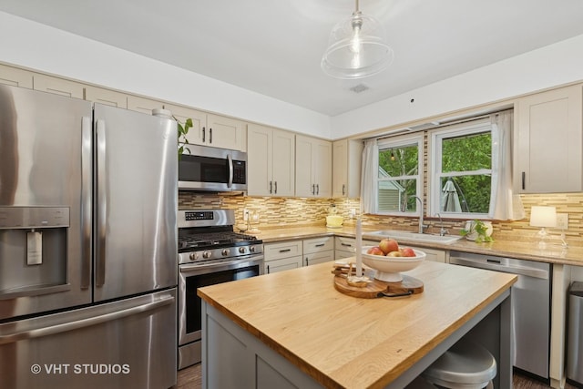207 S Van Buren St, East Dundee, IL 60118 - kitchen featuring stainless steel appliances, wood counters, decorative backsplash, and a center island