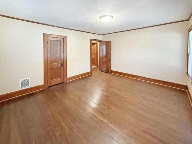 111 E Roosevelt St, Freeport, IL 61032 - empty room featuring wood finished floors, ornamental molding, baseboards, and a textured ceiling