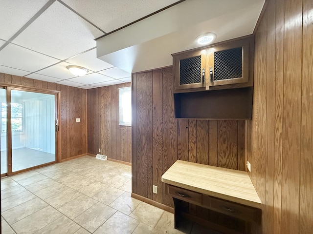 111 E Roosevelt St, Freeport, IL 61032 - interior space with wood walls, baseboards, a paneled ceiling, and light tile patterned floors