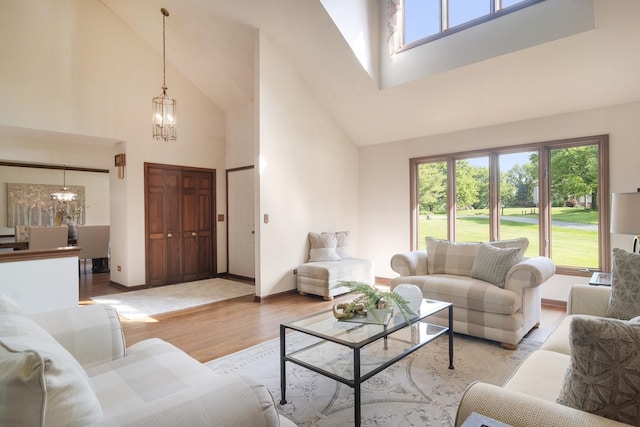 1422 Kirkwall Ct, Inverness, IL 60010 - living room featuring a chandelier, high vaulted ceiling, light wood finished floors, healthy amount of natural light, and baseboards
