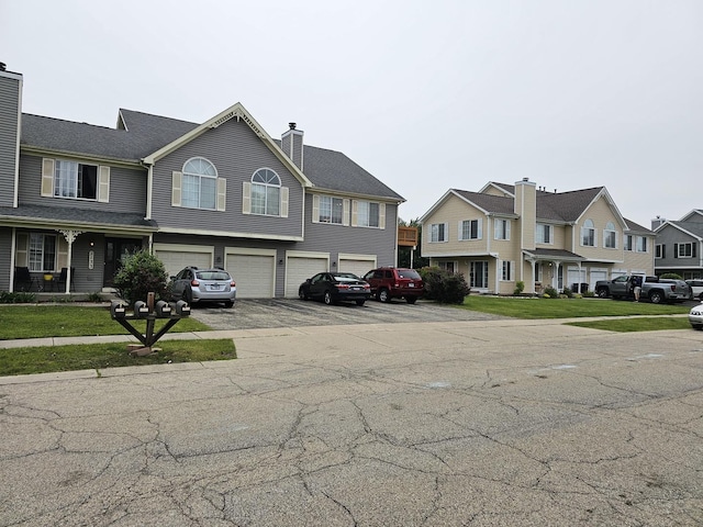 2135 Colorado Ave Unit 2135, Elgin, IL 60123 - view of front of house with an attached garage, a chimney, driveway, and a residential view