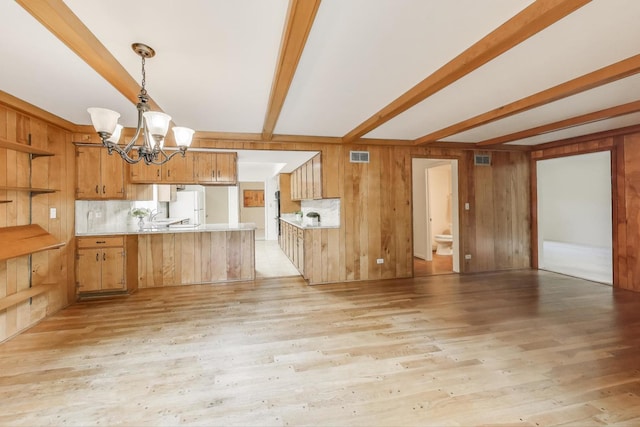 1904 Birch Rd, Northbrook, IL 60062 - kitchen with a peninsula, beam ceiling, freestanding refrigerator, a chandelier, and light countertops