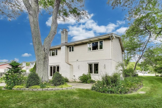 1904 Birch Rd, Northbrook, IL 60062 - back of property with a chimney, a lawn, and brick siding