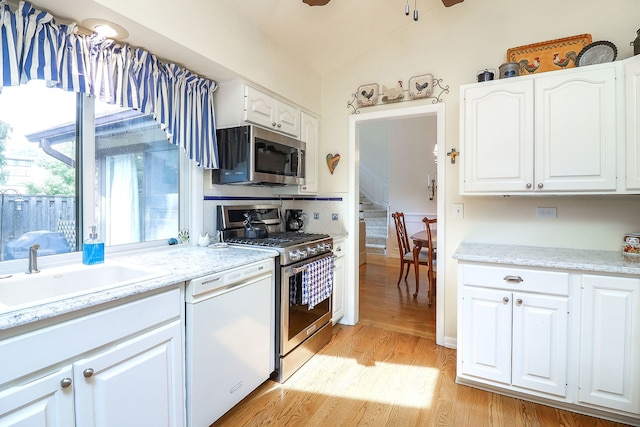 12 Kyle Ct, Willowbrook, IL 60527 - kitchen featuring appliances with stainless steel finishes, a sink, light wood finished floors, white cabinets, and tasteful backsplash