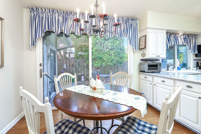 12 Kyle Ct, Willowbrook, IL 60527 - dining area featuring a chandelier, wood finished floors, and baseboards
