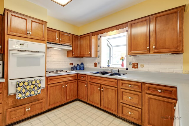 1103 S Belmont Ave, Arlington Heights, IL 60005 - kitchen with brown cabinetry, white appliances, light countertops, tasteful backsplash, and under cabinet range hood