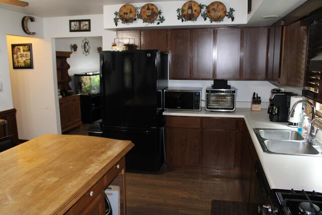 907 N Eddy St, Sandwich, IL 60548 - kitchen with freestanding refrigerator, a sink, dark brown cabinetry, dark wood-style floors, and wood counters