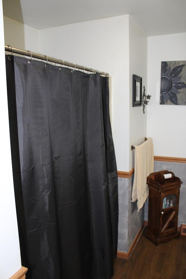 907 N Eddy St, Sandwich, IL 60548 - full bathroom with wood finished floors, baseboards, and curtained shower
