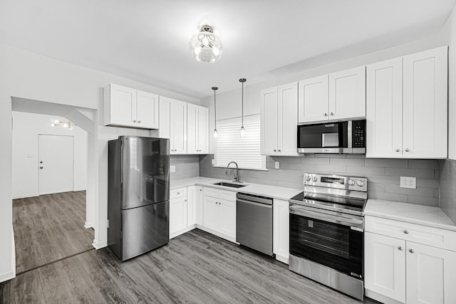 11357 S Indiana Ave, Chicago, IL 60628 - kitchen featuring appliances with stainless steel finishes, light countertops, white cabinets, and decorative backsplash