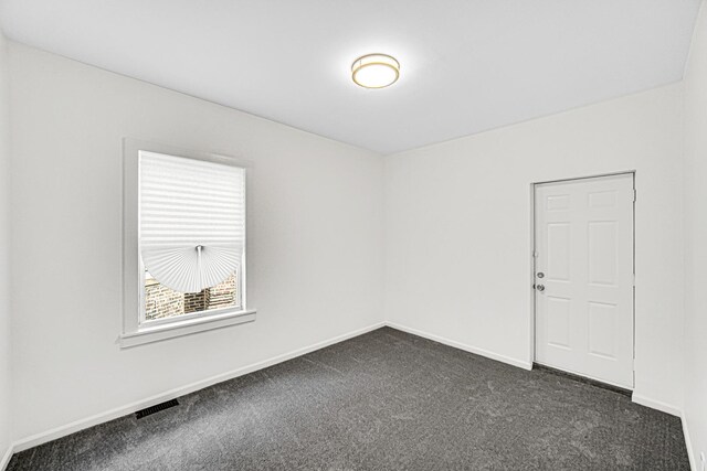 11357 S Indiana Ave, Chicago, IL 60628 - empty room featuring dark carpet and baseboards