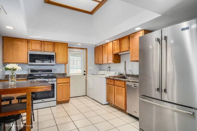 1N559 Newton Ave, Glen Ellyn, IL 60137 - kitchen featuring appliances with stainless steel finishes, independent washer and dryer, a sink, a tray ceiling, and dark countertops
