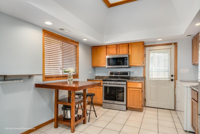 1N559 Newton Ave, Glen Ellyn, IL 60137 - kitchen with appliances with stainless steel finishes, recessed lighting, light tile patterned floors, brown cabinetry, and washer and clothes dryer