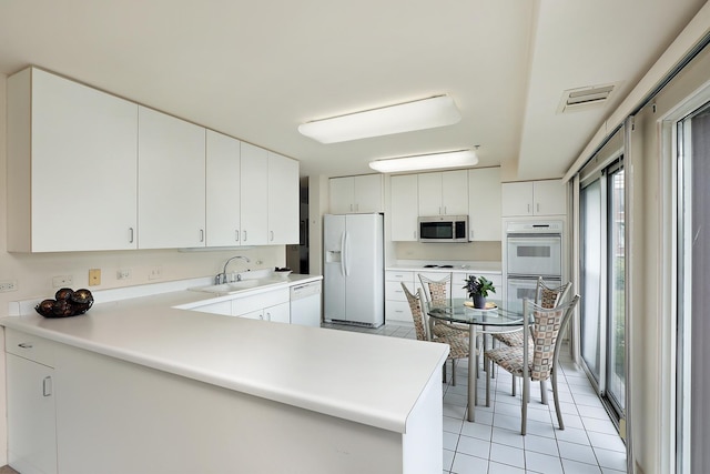 422 Kelburn Rd Unit 223, Deerfield, IL 60015 - kitchen with white appliances, light tile patterned flooring, a peninsula, light countertops, and white cabinets