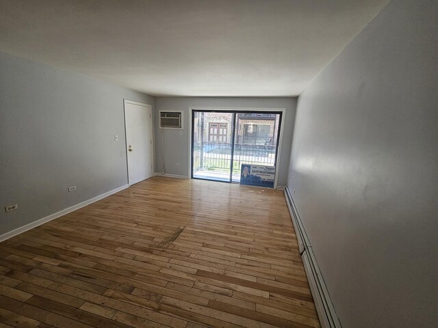 5349 N Delphia Ave Unit 150, Chicago, IL 60656 - spare room with wood-type flooring, a wall unit AC, and baseboards