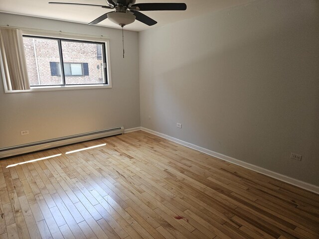5349 N Delphia Ave Unit 150, Chicago, IL 60656 - empty room featuring ceiling fan, baseboard heating, hardwood / wood-style floors, and baseboards