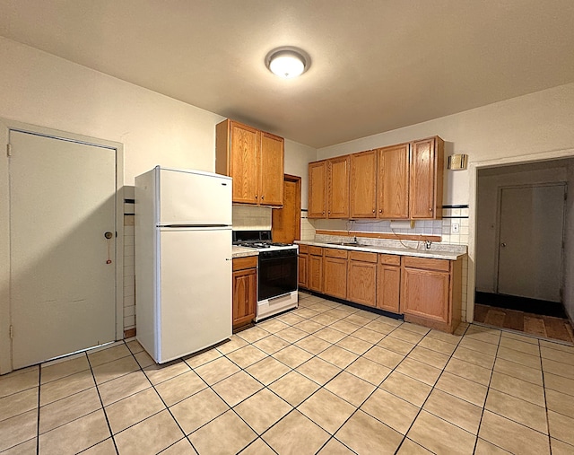 2717 W 38th St, Chicago, IL 60632 - kitchen with range with gas stovetop, freestanding refrigerator, light countertops, and brown cabinetry