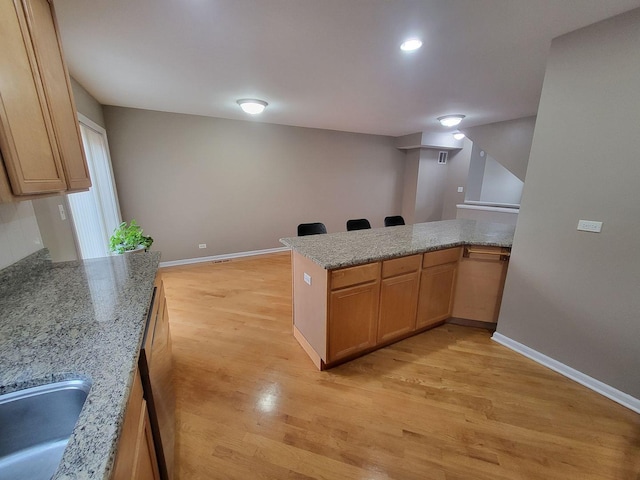 3041 W Pope John Paul Ii Dr, Chicago, IL 60638 - kitchen featuring light wood-style floors, a peninsula, a sink, and baseboards